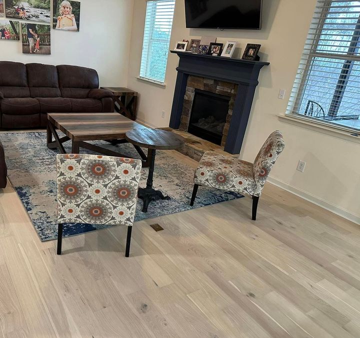 a living room with a couch , chairs , coffee table and fireplace .