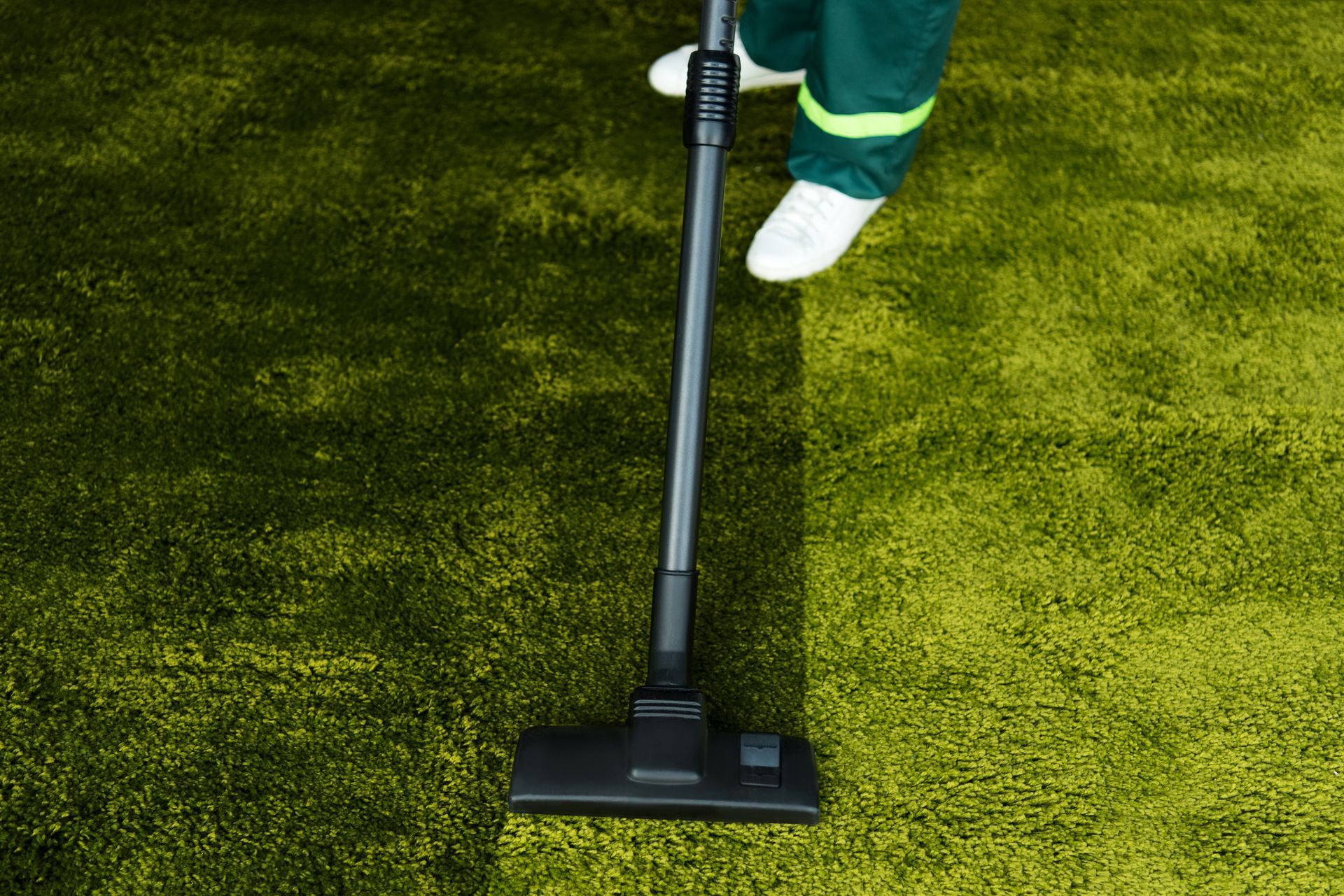 An expert from Xander's Services & Carpet Cleaning providing turf cleaning service in Summerlin, NV, using a vacuum cleaner.
