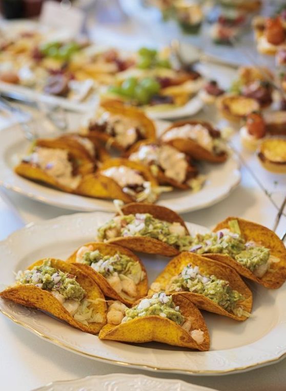 A white plate topped with tacos and guacamole on a table.