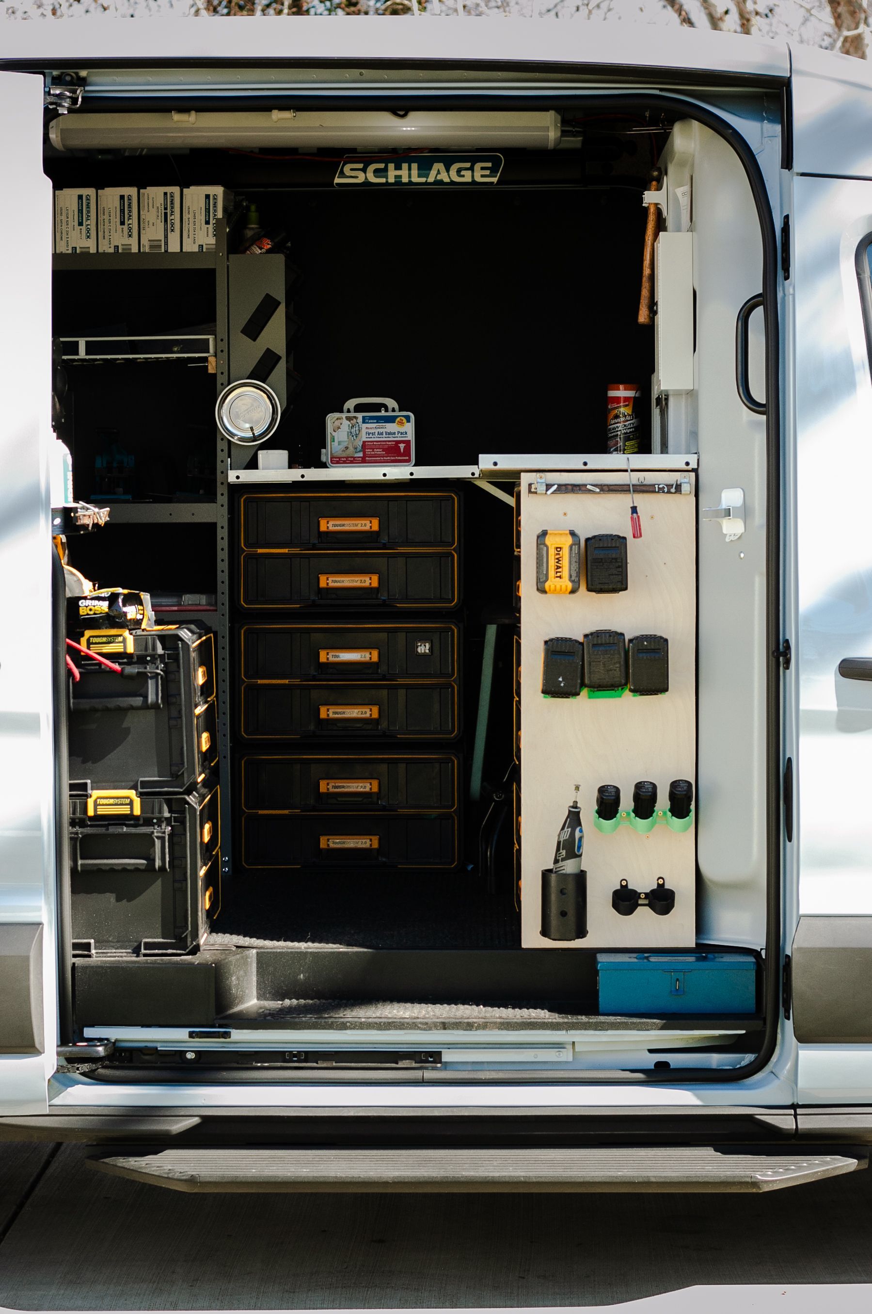 The back of a van with the door open and a shelf with tools on it