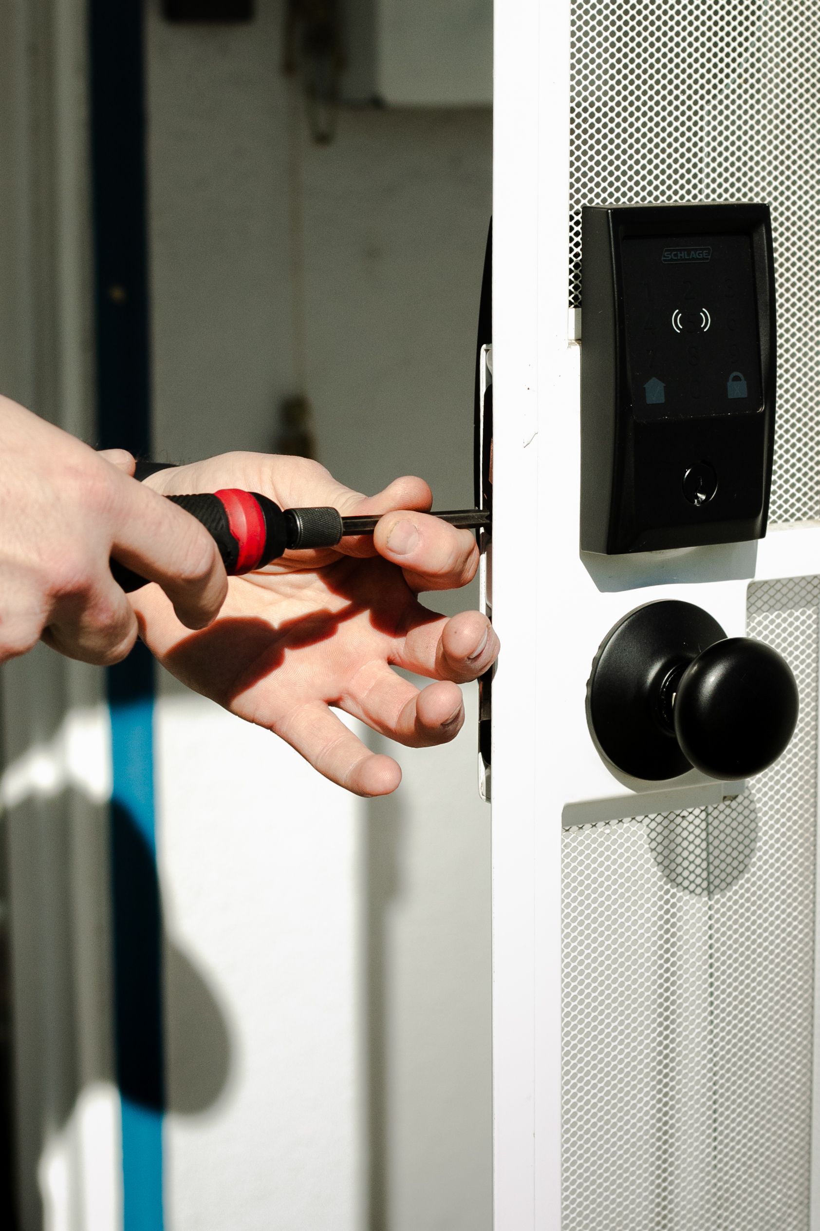 A person is fixing a door with a screwdriver