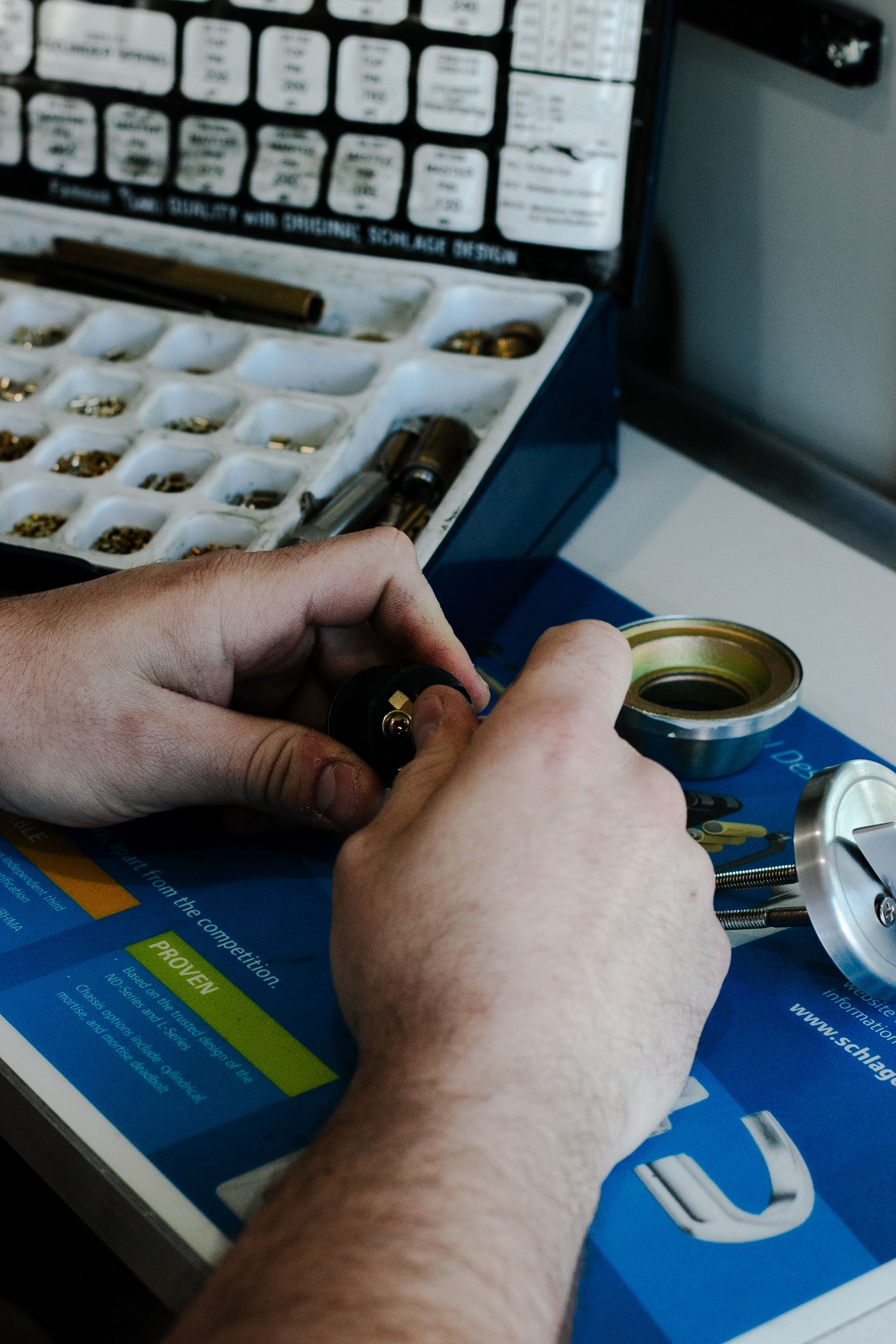 A person is working on a lock with a magnifying glass