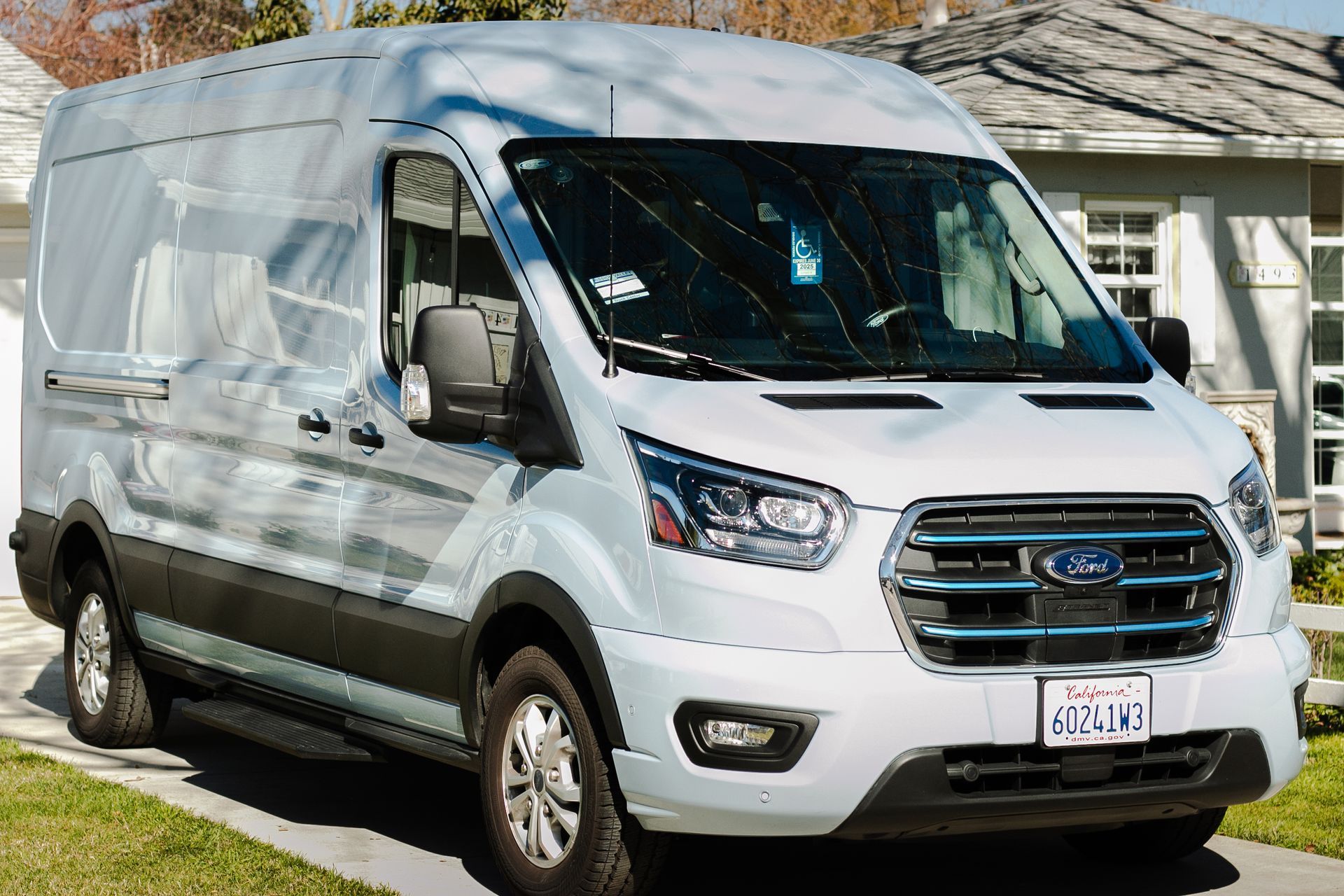 A white van is parked in front of a house.