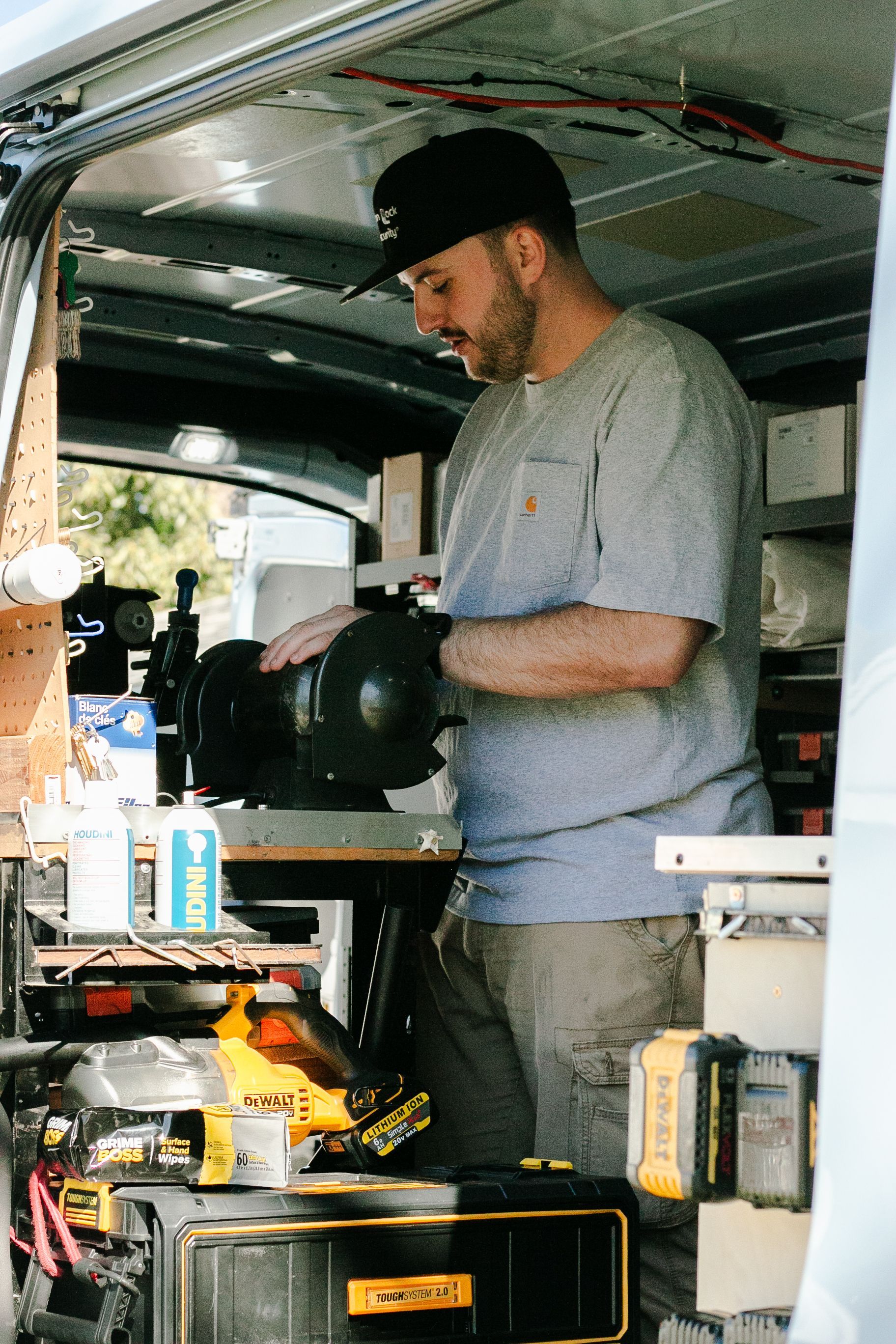 A man is working on a machine in the back of a van.