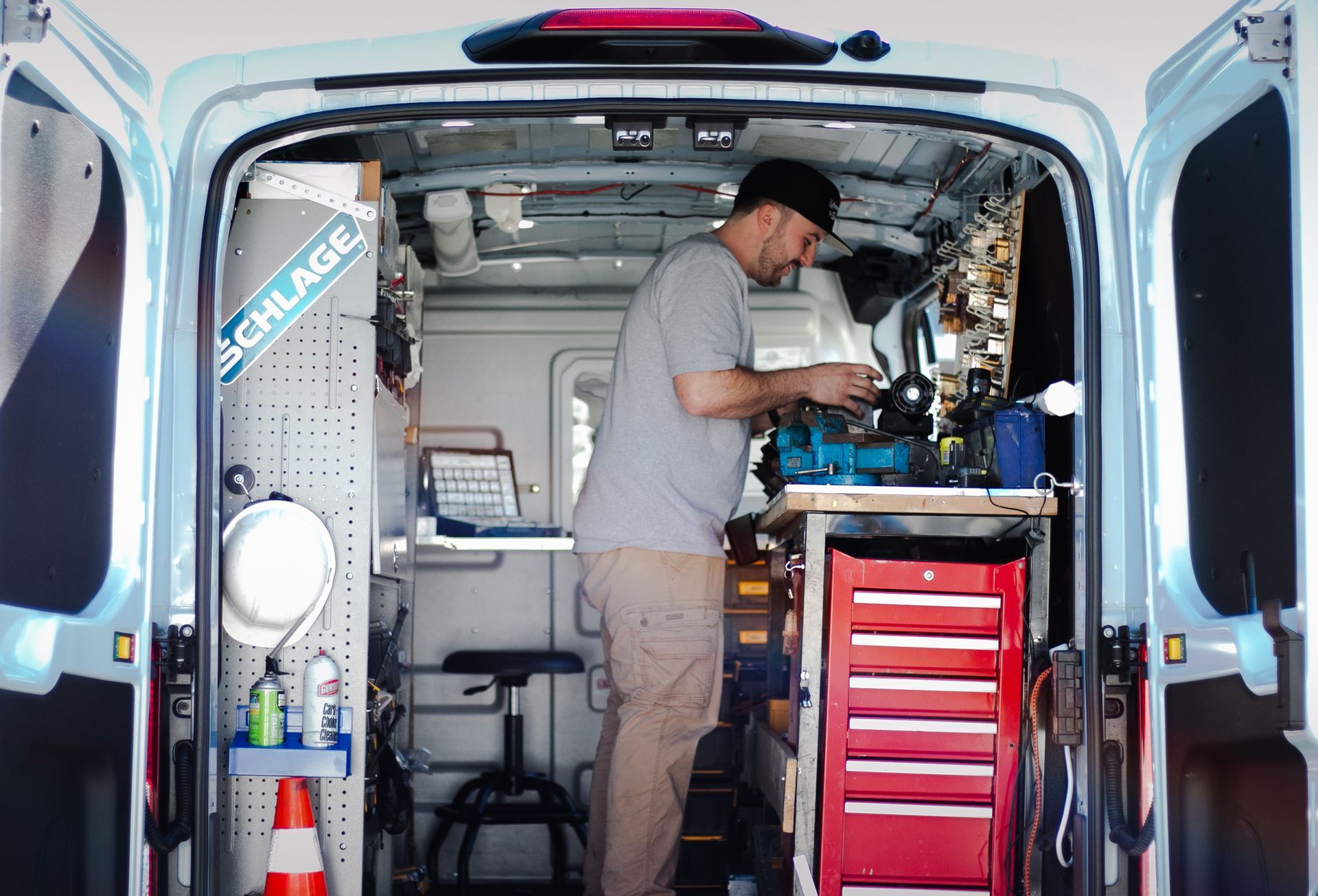 A man is working in the back of a van.