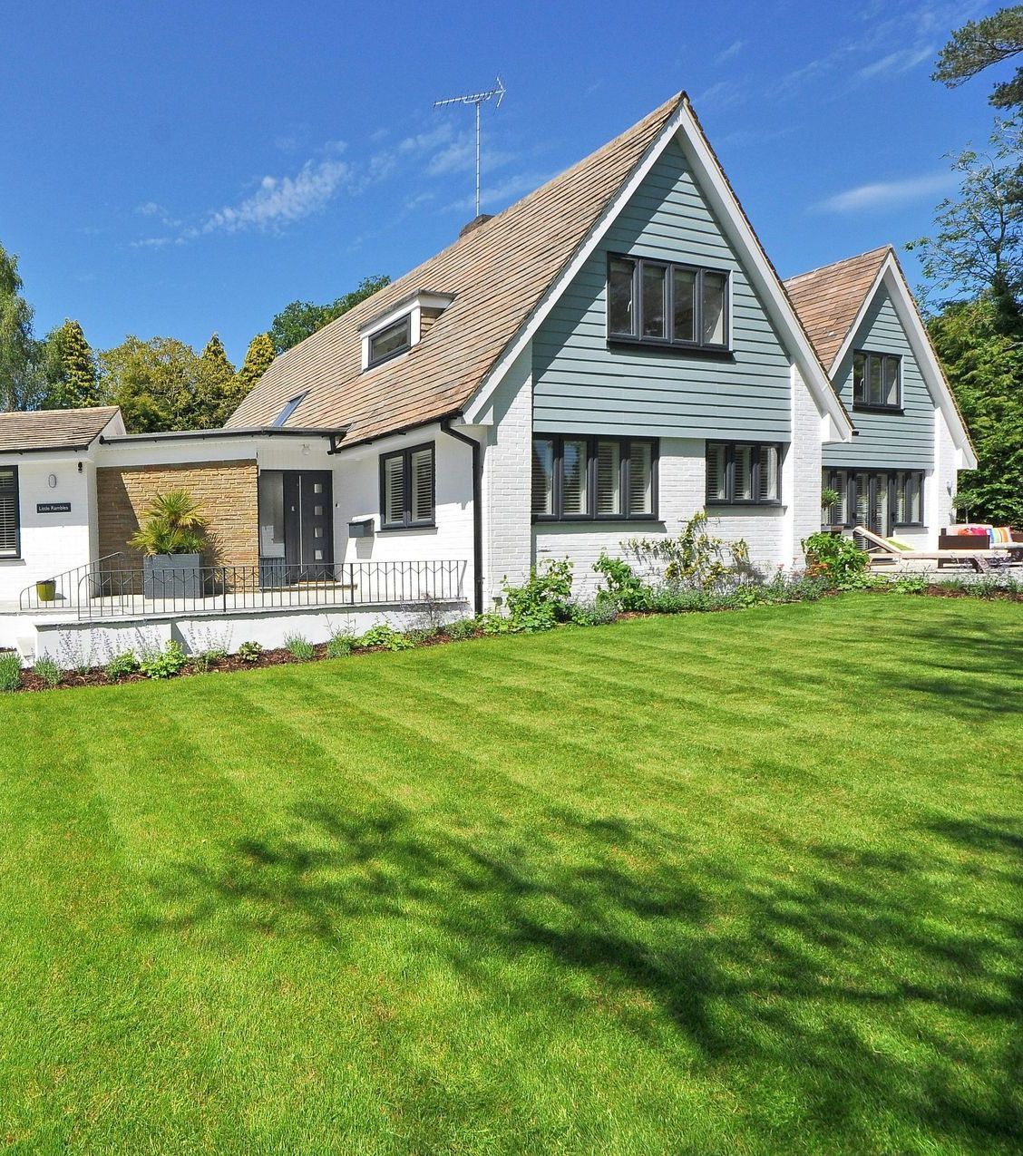 A large house with a lush green lawn in front of it.