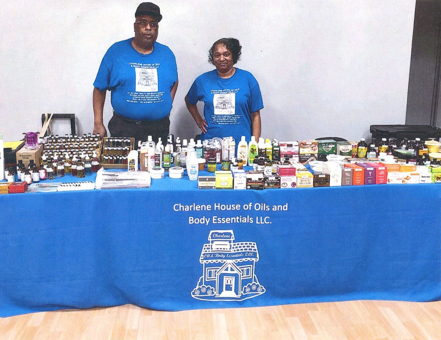 Two people at a table with products, promoting 