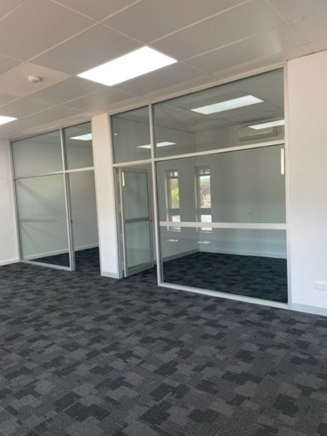 A room with a lot of windows and a carpeted floor