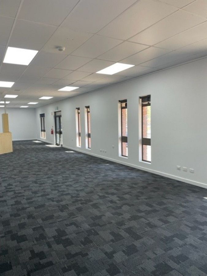 A large empty room with a carpeted floor and white walls.
