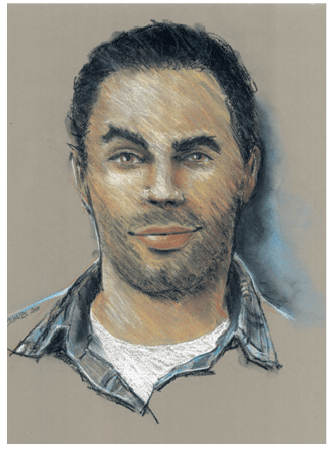 Portrait of a man with dark hair, a slight smile, and stubble, wearing a denim shirt over a white t-shirt.