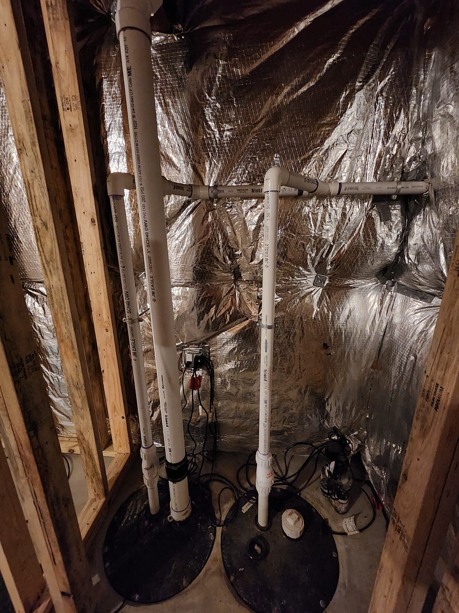 Basement utility area with pipes, water heater, and reflective insulation against wall