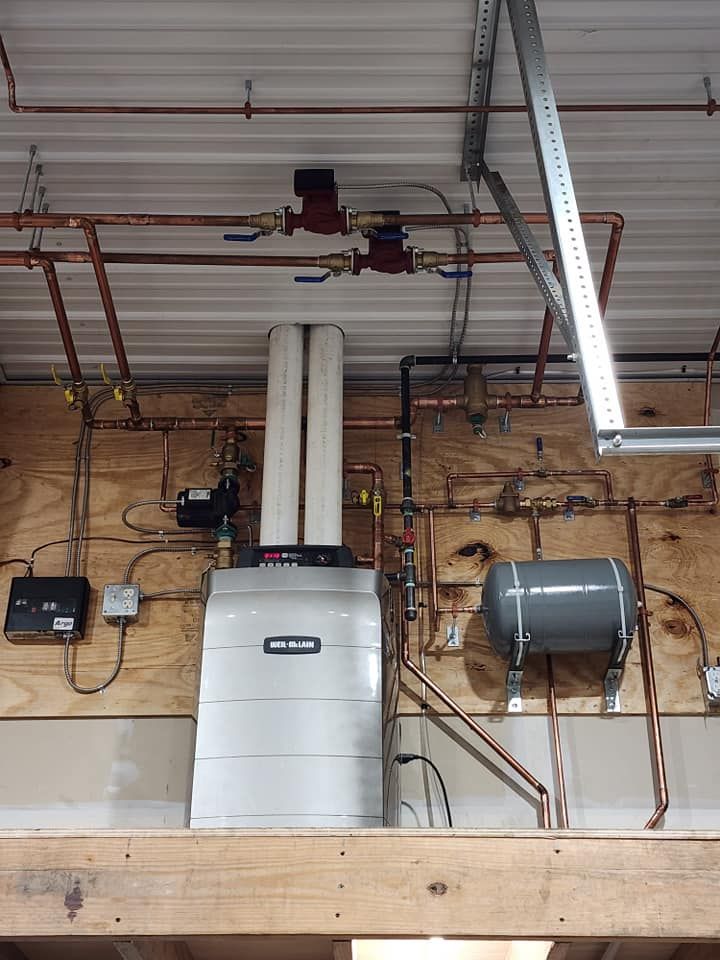 Ceiling-mounted HVAC and ductwork in an unfinished industrial interior with exposed pipes and beams