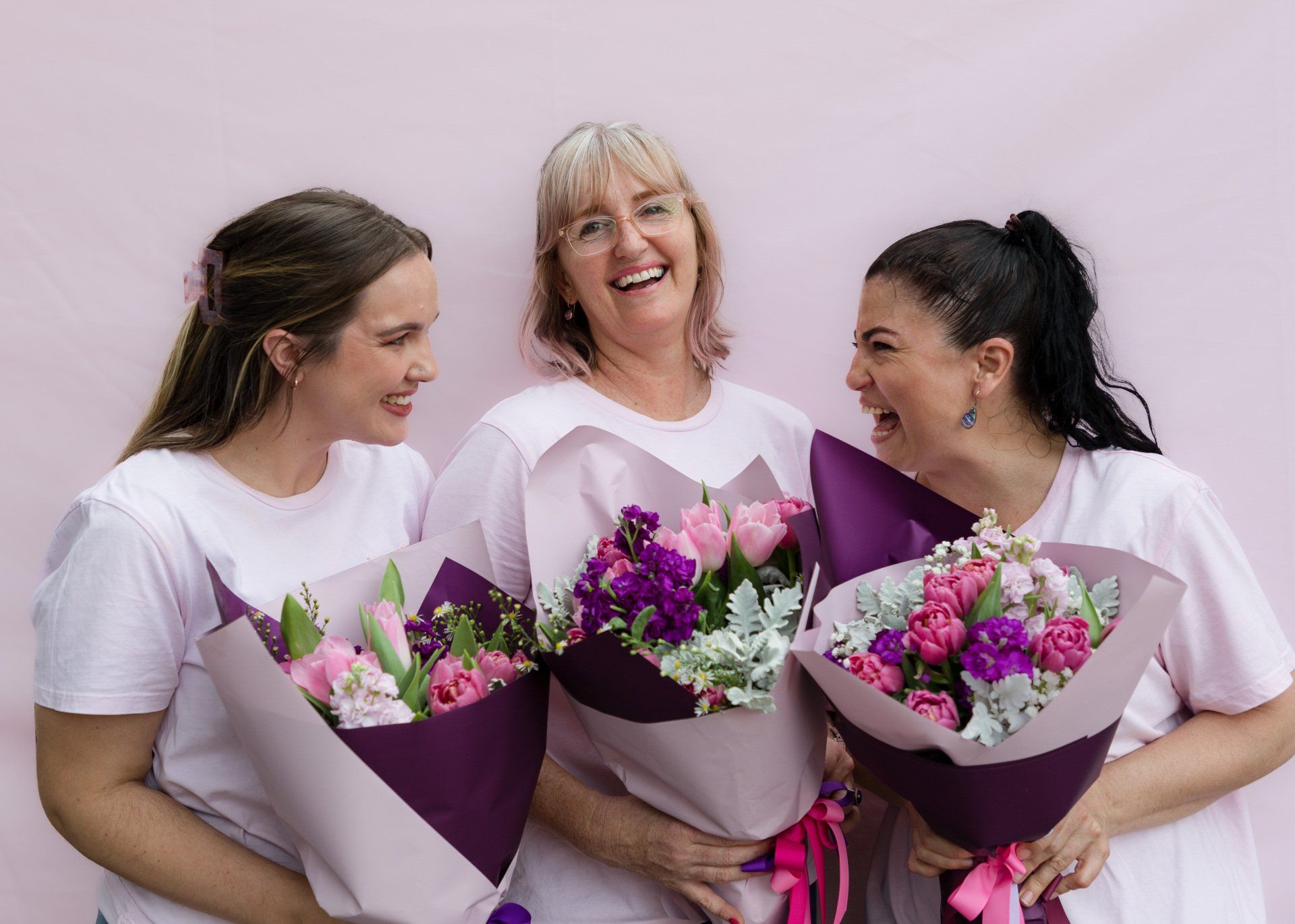 Cheerful Darwin floral team with purple flower arrangements, reflecting a sense of community and harmony.