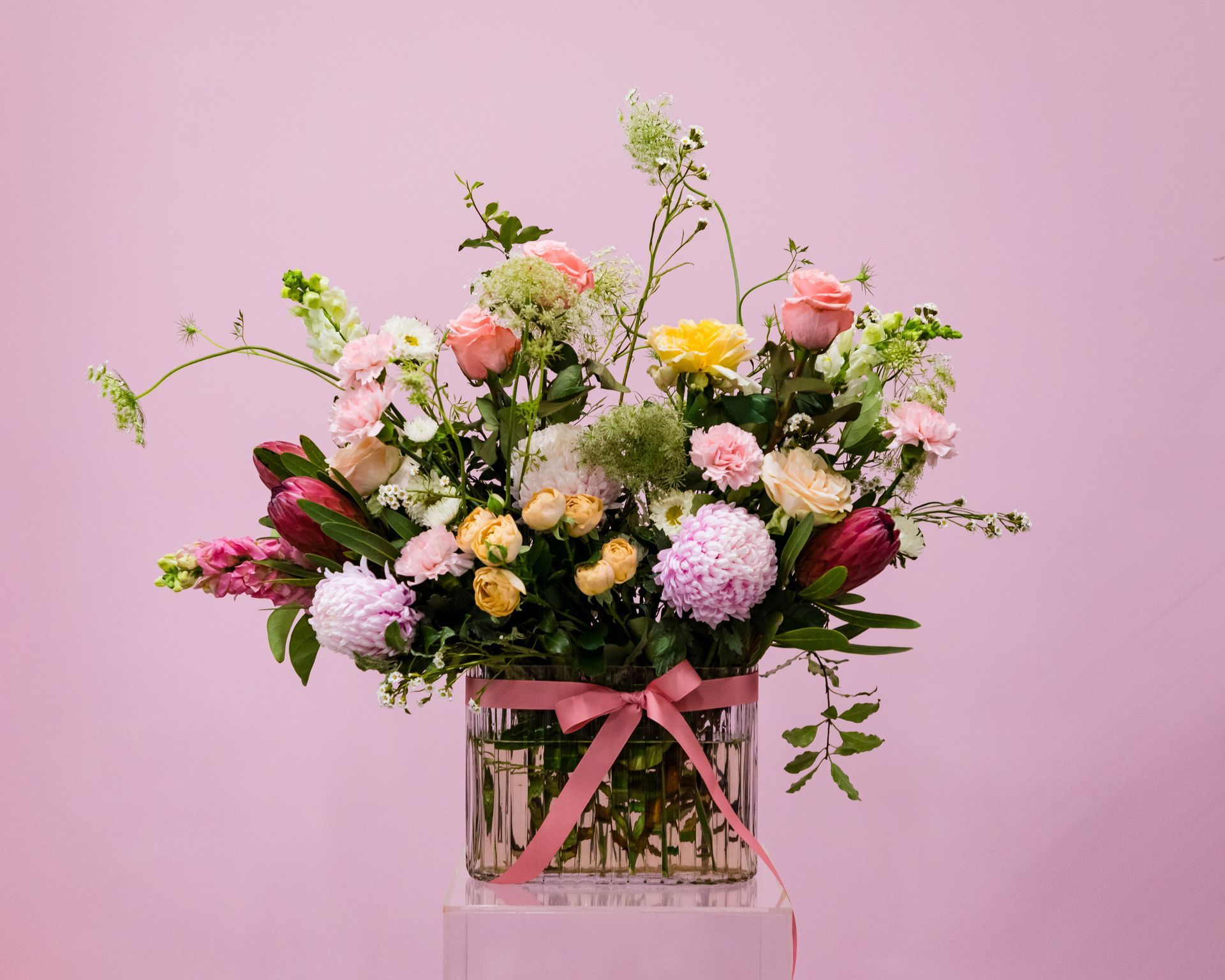 Darwin flower shop's team, all smiles, proudly displaying purple blooms, symbolizing joy and togetherness.