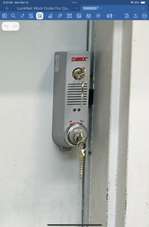 Wall-mounted electric water heater control panel with silver knobs and red logo on a white wall