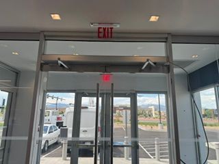 Entrance with glass doors and EXIT sign, looking outside to a parking lot.