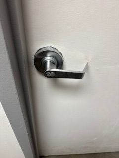 Close-up of a silver door lever handle on a white door frame