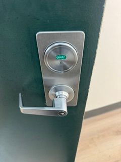 Green door with silver keypad lock and lever handle