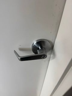 Silver door handle on a white interior door, close-up.