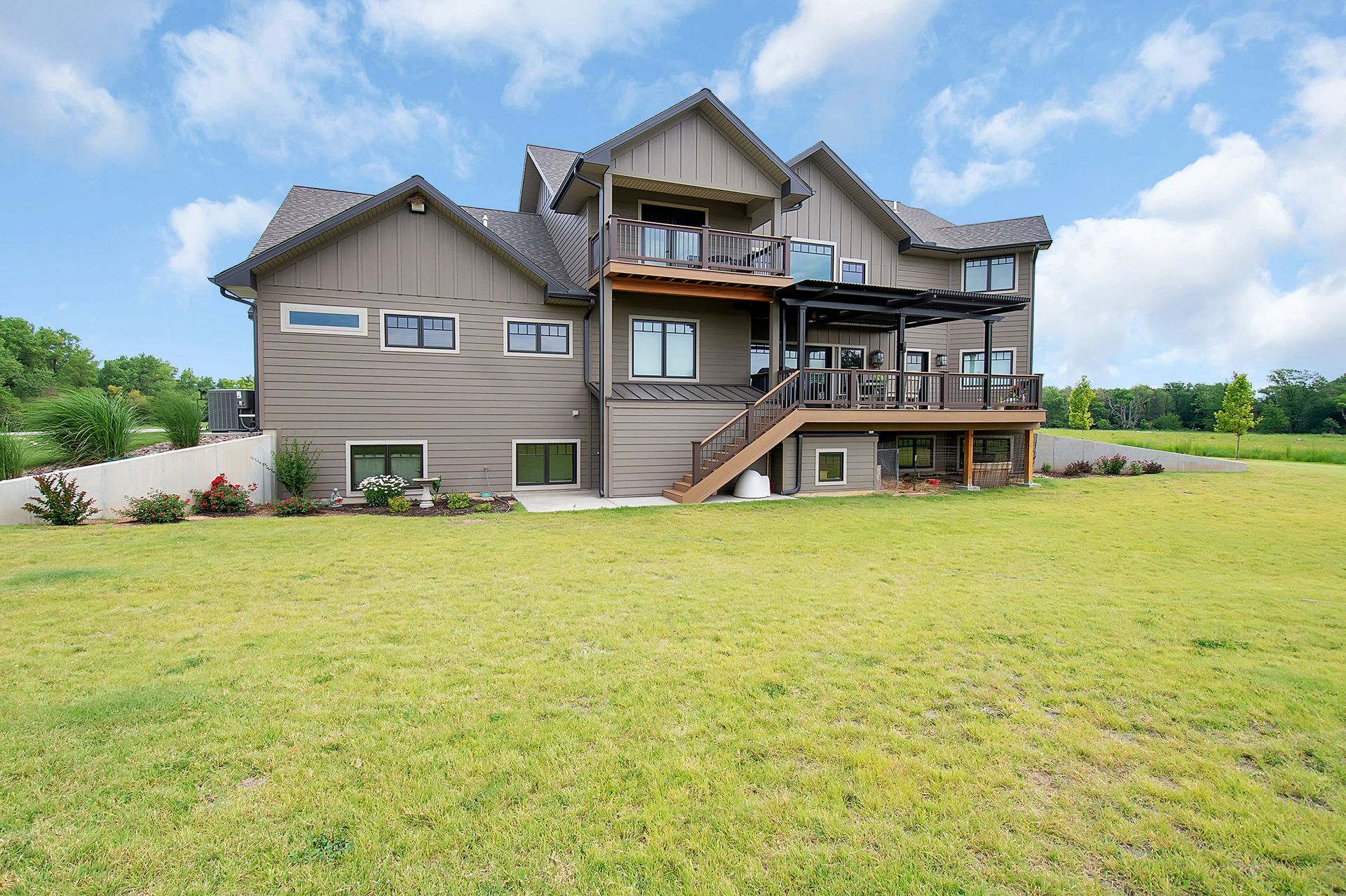A large house is sitting on top of a lush green field.