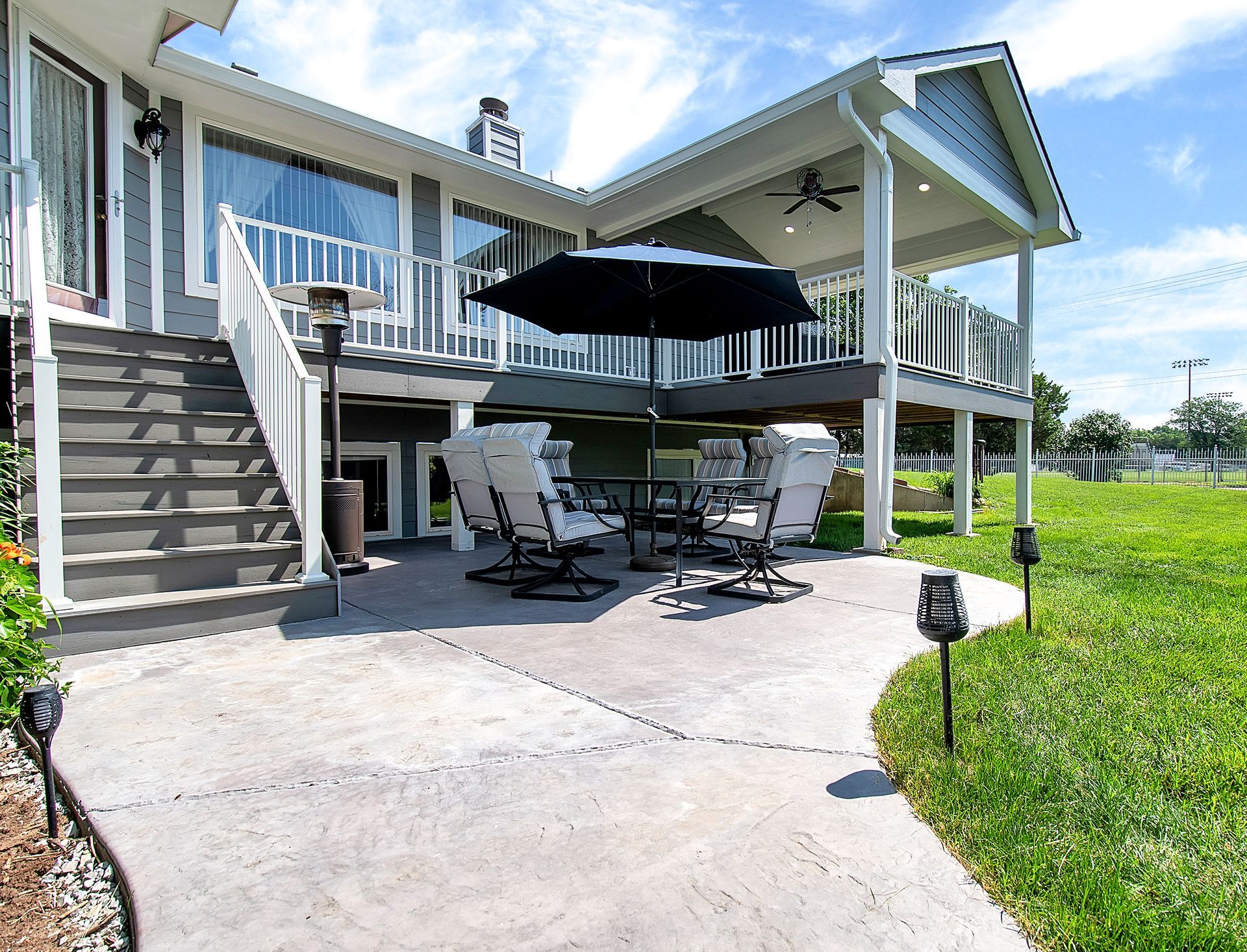 A large house with a patio with a table and chairs and an umbrella