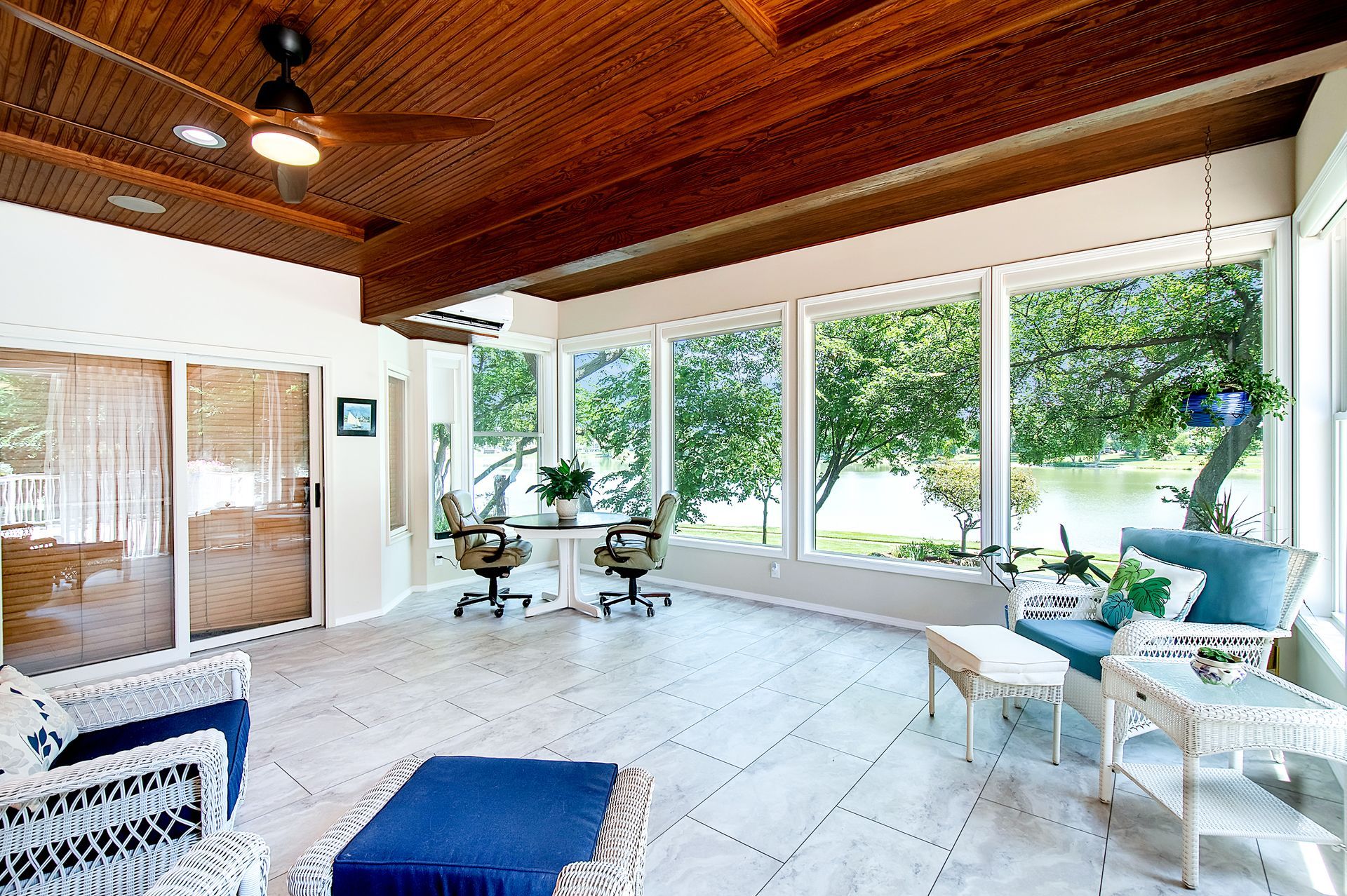 A living room with a lot of windows and a ceiling fan
