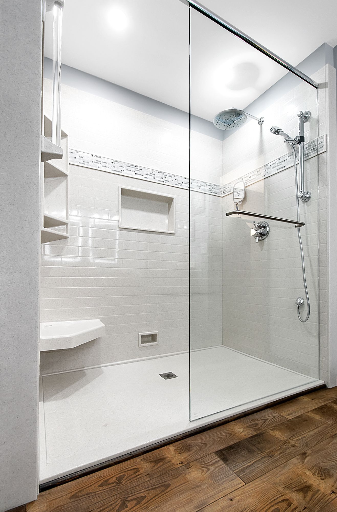A bathroom with a walk in shower with a glass door.