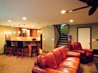 A living room with a couch and chairs and a ceiling fan