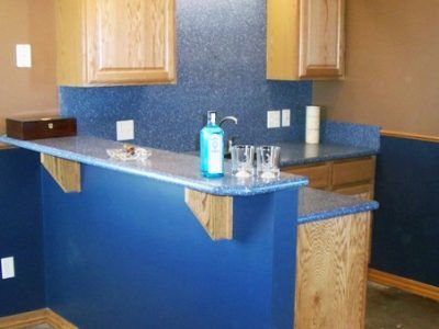 A kitchen with a blue counter top and wooden cabinets.