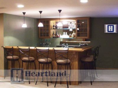 A bar with stools and a sign that says heartland