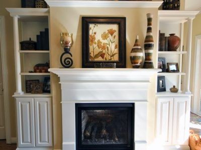 A fireplace in a living room with a picture above it
