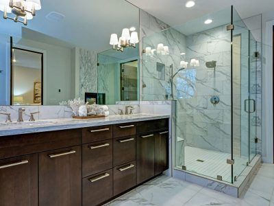 A bathroom with two sinks , a walk in shower and a large mirror.