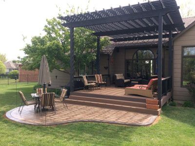 A patio with a table and chairs under a pergola.