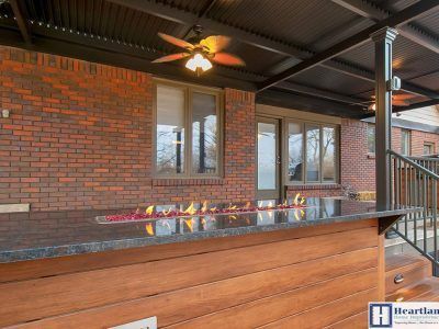A brick house with a fire pit and a ceiling fan.