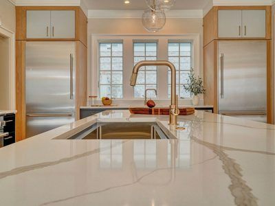 A kitchen with a sink , refrigerator , and stainless steel appliances.