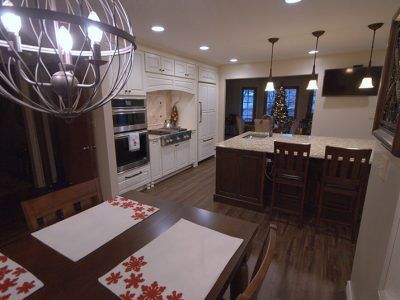 A kitchen with a table and chairs and a christmas tree in the background