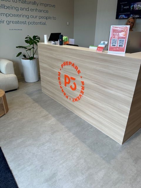A Reception Desk In A Room With A Clock On The Wall — Northern Territory Sign Services in Winnellie, NT