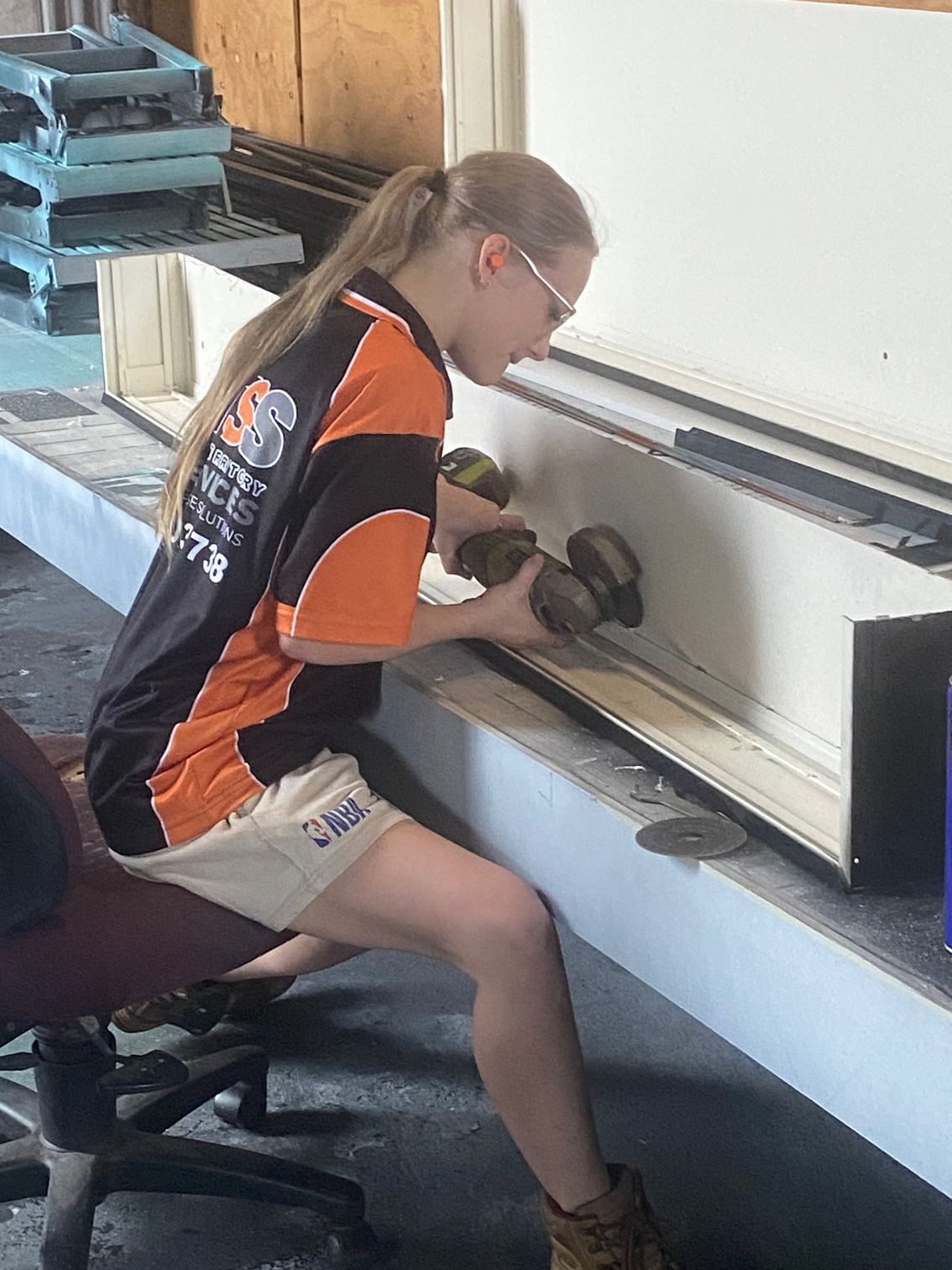 Two Men Are Working On A Boat In A Garage — Northern Territory Sign Services in Winnellie, NT