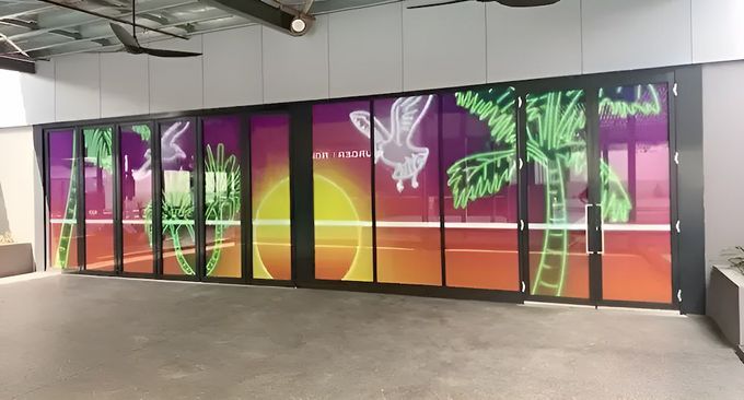 A Sliding Glass Door With A Painting Of A Sunset On It — Northern Territory Sign Services in Winnellie, NT