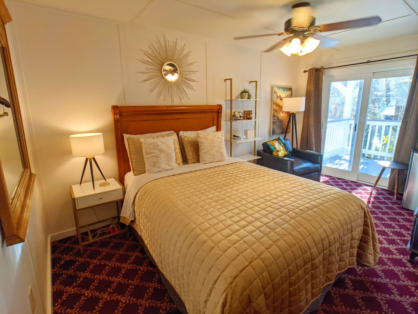 A bedroom with a king size bed and a ceiling fan.