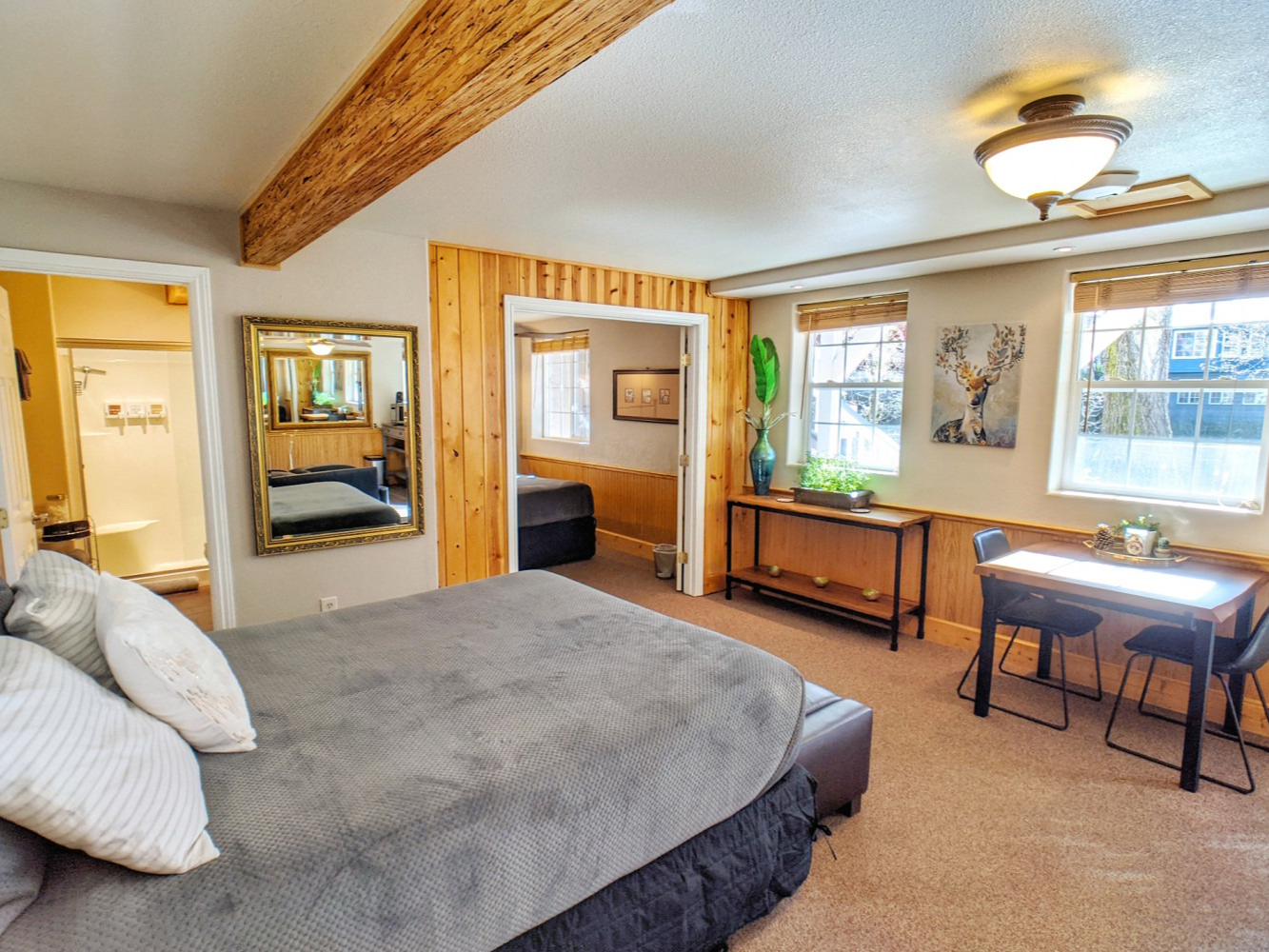 A bedroom with a king size bed , a table and chairs.