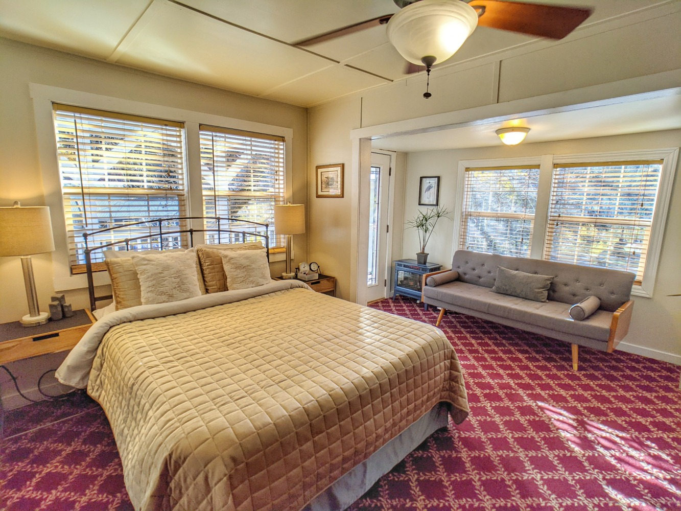 A bedroom with a bed , couch , and ceiling fan.