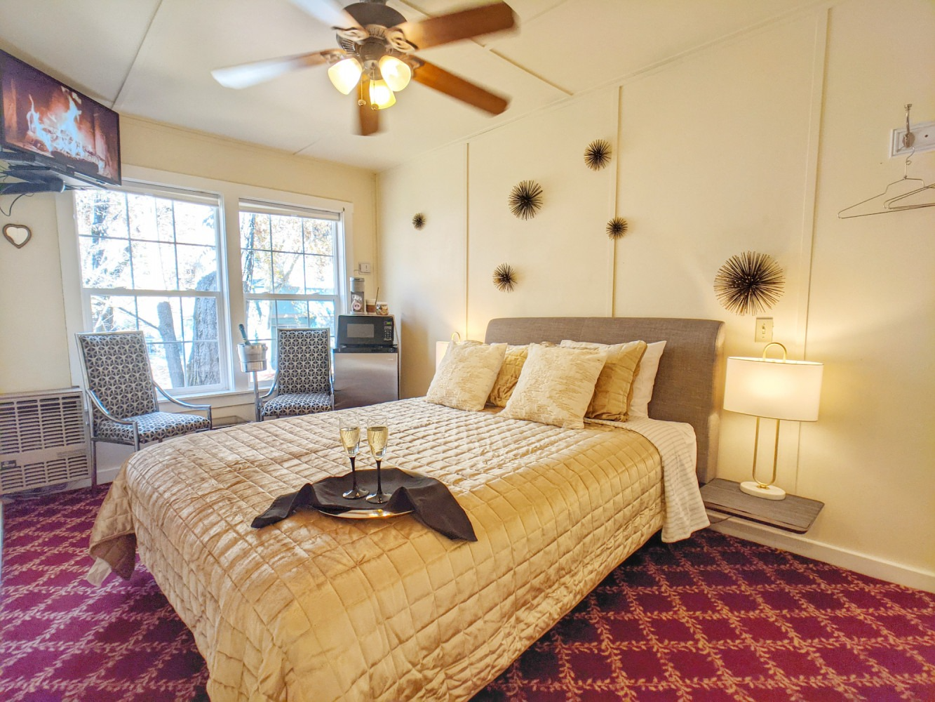 A bedroom with a king size bed and a ceiling fan.