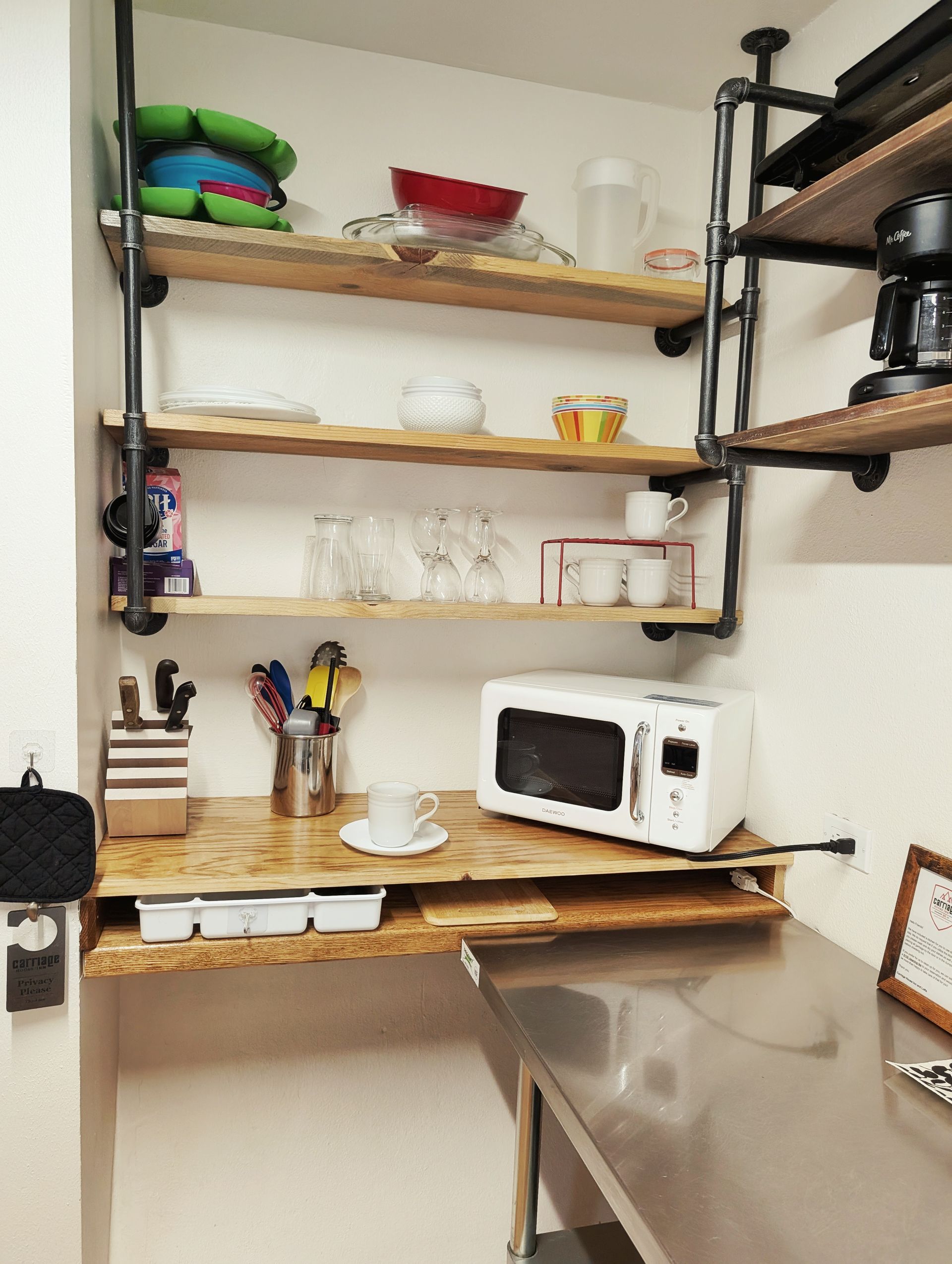 A microwave is sitting on a shelf in a kitchen