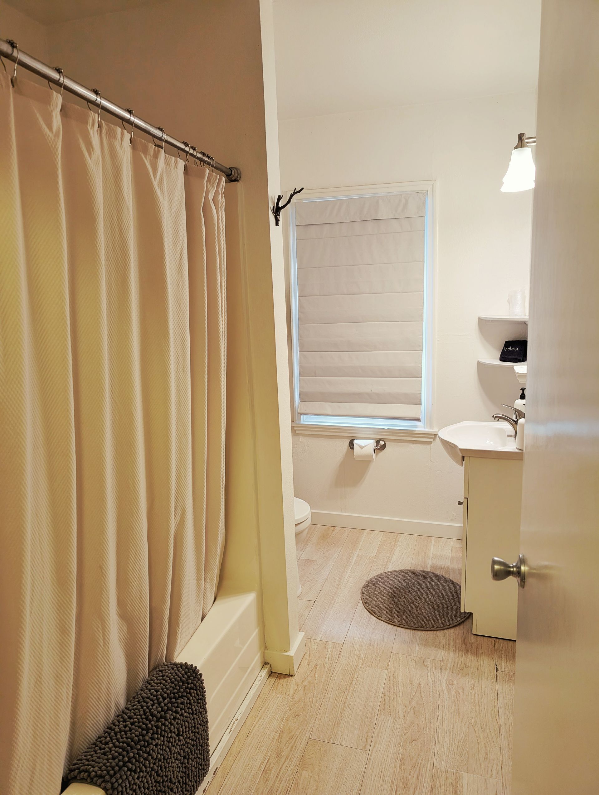 A bathroom with a sink a tub and a window