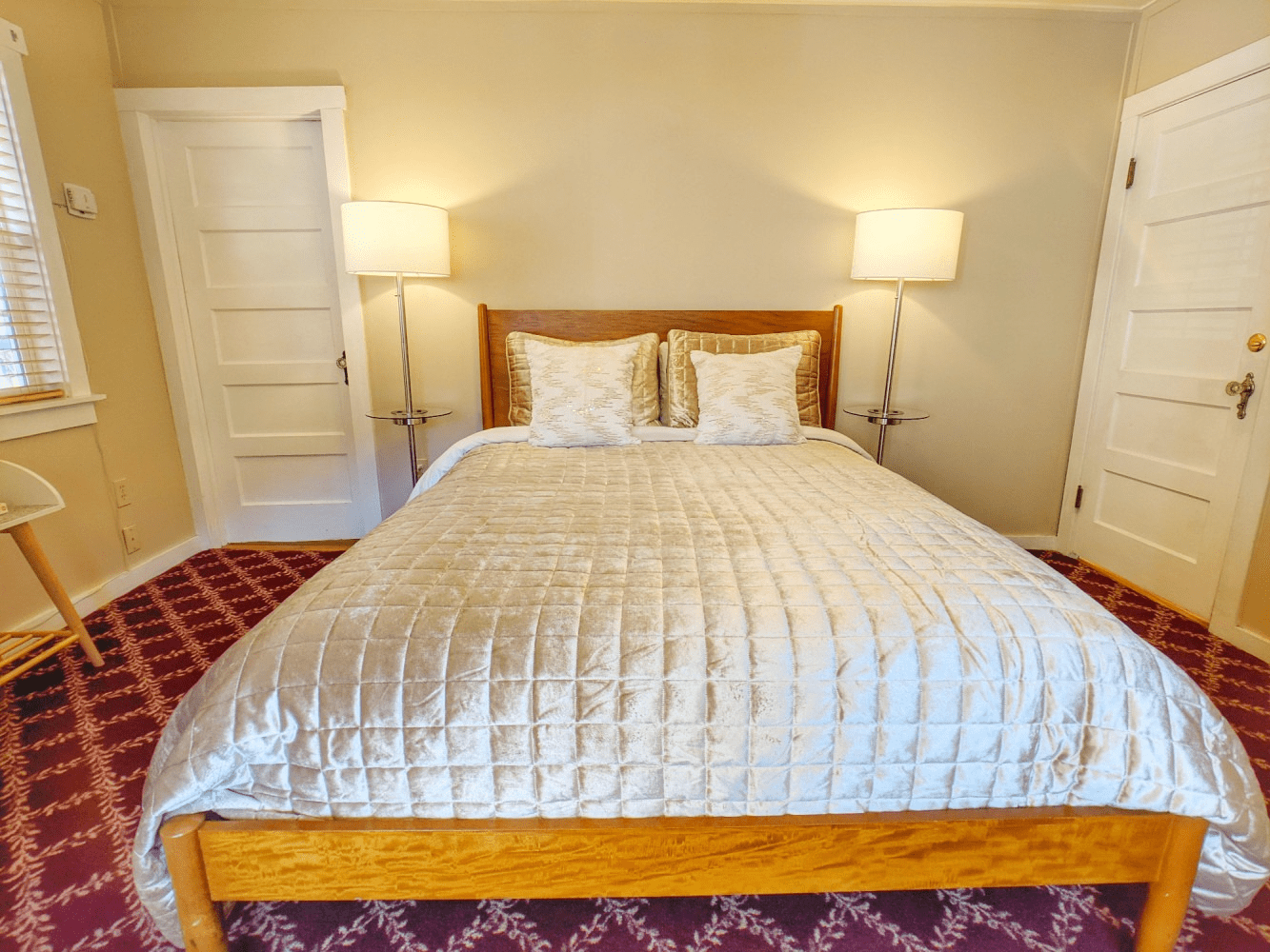 A bedroom with a bed and two lamps