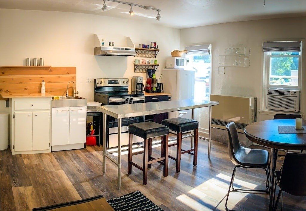 A kitchen with a table and chairs and a stove.