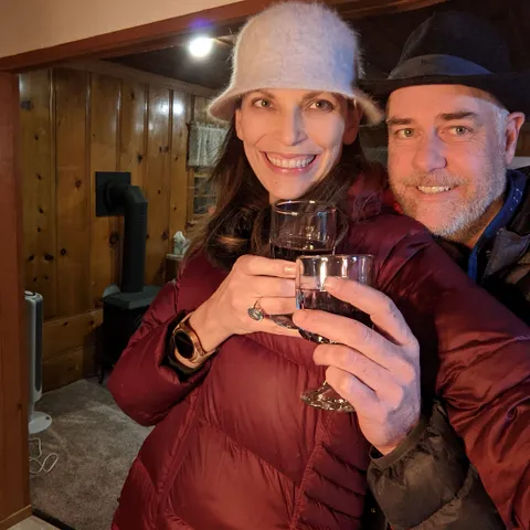 A man and a woman are holding wine glasses and smiling.