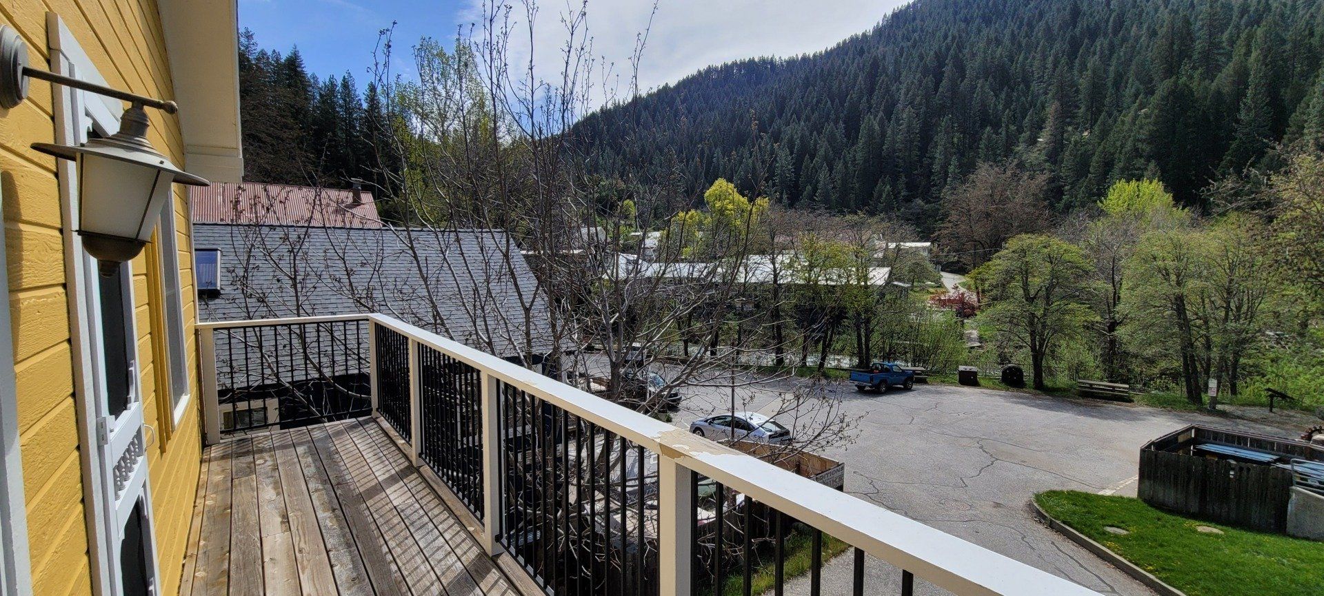 There is a balcony with a view of the mountains and trees.