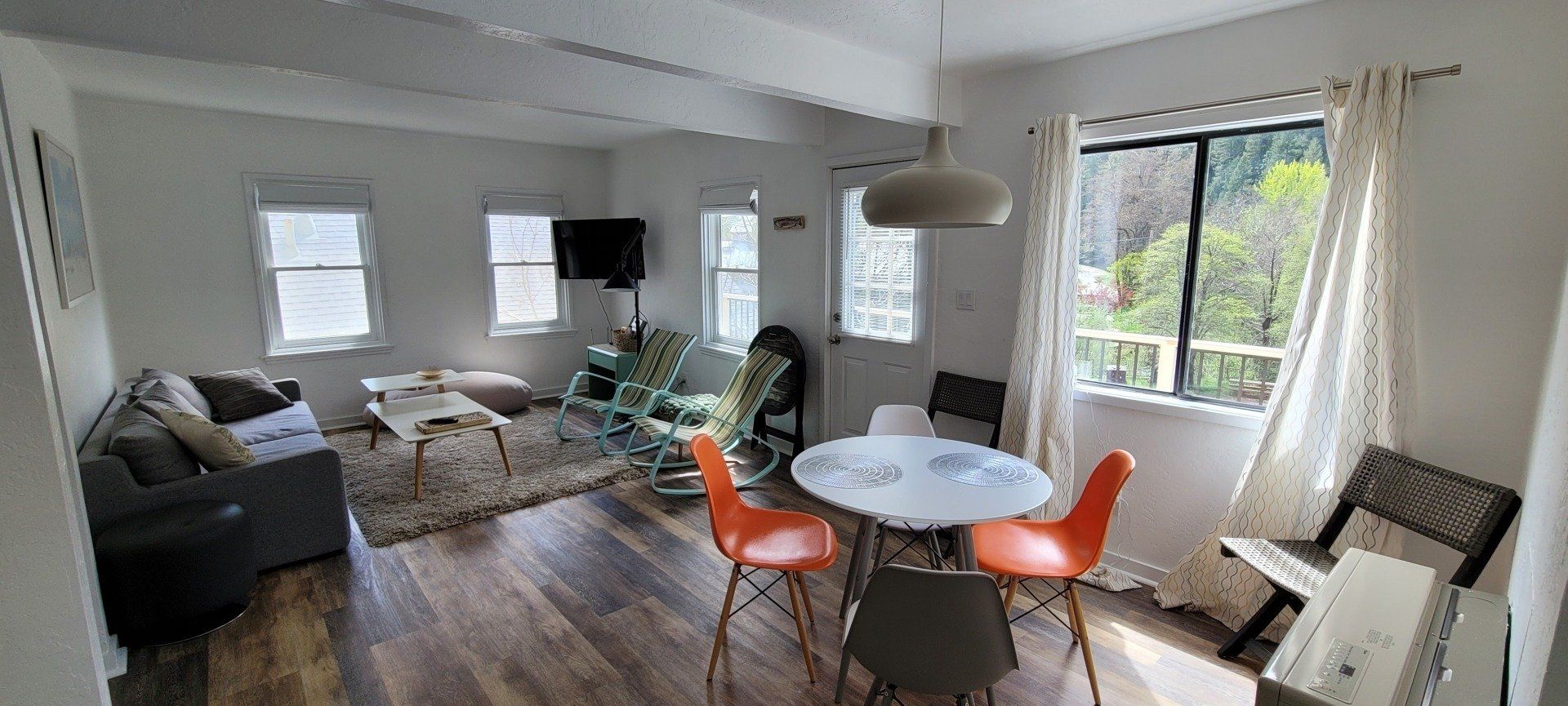 A living room with a table and chairs and a couch.